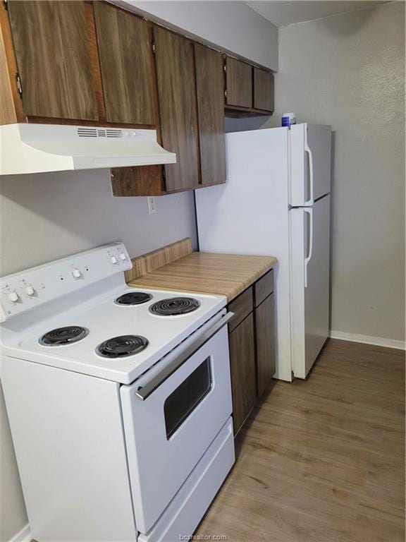 kitchen with white appliances and light hardwood / wood-style flooring