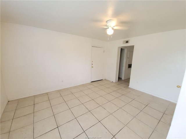 tiled empty room featuring ceiling fan