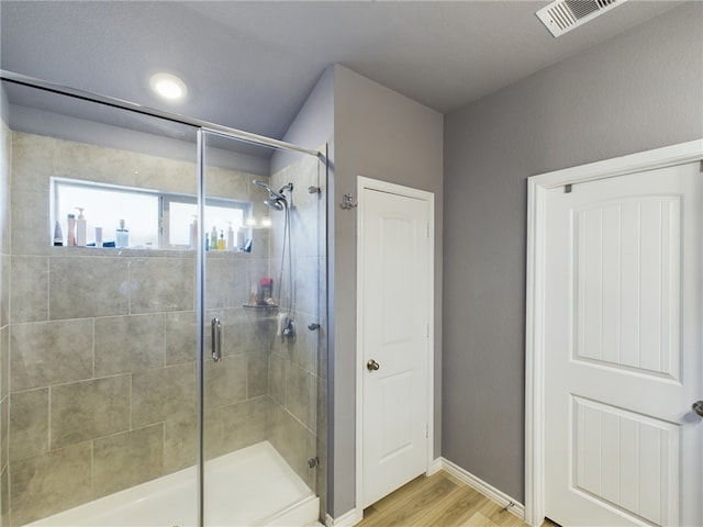 bathroom with wood-type flooring and walk in shower