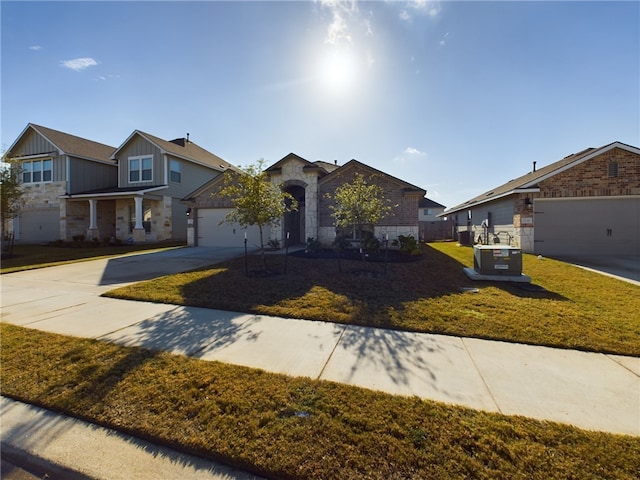 view of front of home with a front yard, a garage, and central air condition unit