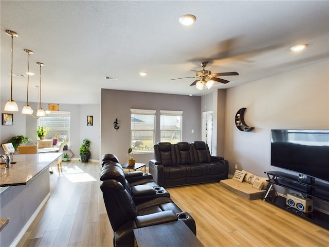 living room featuring a wealth of natural light, ceiling fan, and hardwood / wood-style flooring