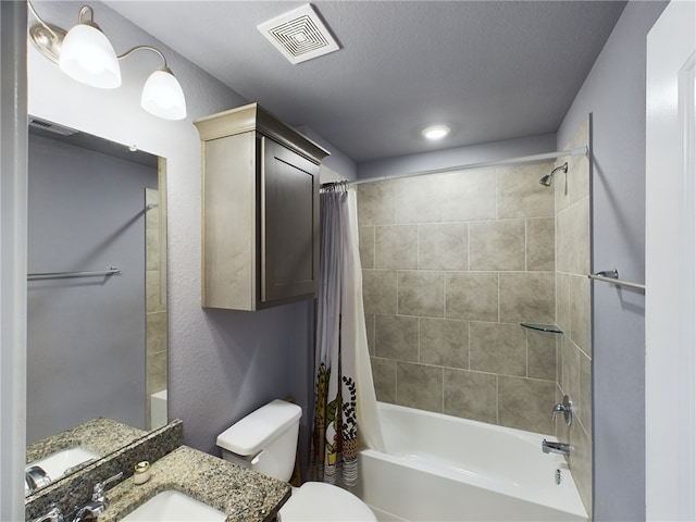 full bathroom featuring shower / bath combo with shower curtain, vanity, a textured ceiling, and toilet