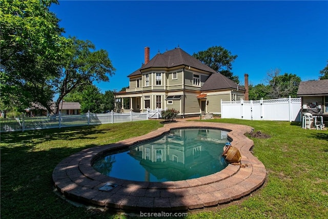 back of house with a fenced in pool and a yard