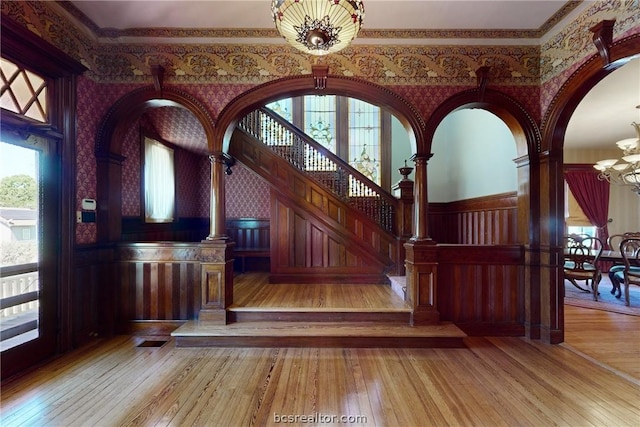 interior space with light wood-type flooring, ornamental molding, and a chandelier