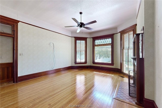 unfurnished room featuring ceiling fan, a textured ceiling, and light wood-type flooring