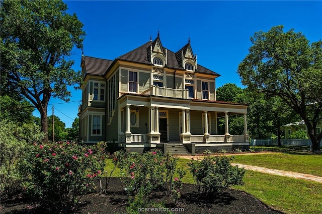 victorian house with a porch and a front yard