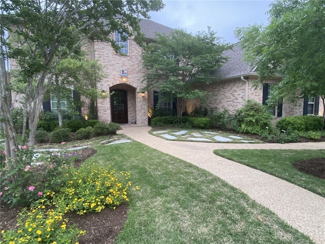 5311 Riviera Ct, College Station, TX 77845 - view of front of home featuring brick siding, roof with shingles, and a front yard