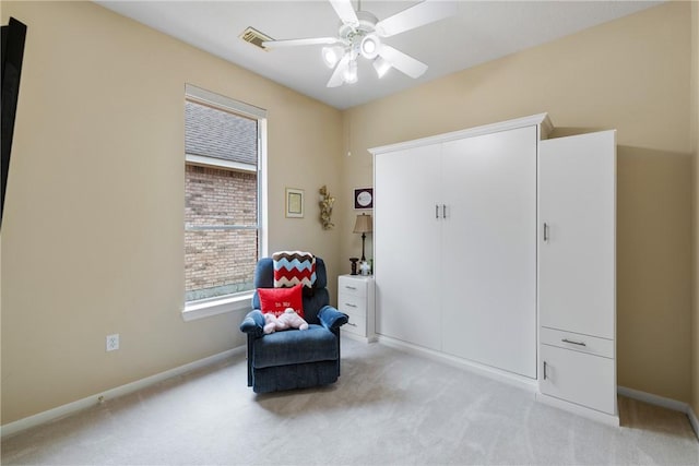 living area featuring light colored carpet, baseboards, ceiling fan, and visible vents