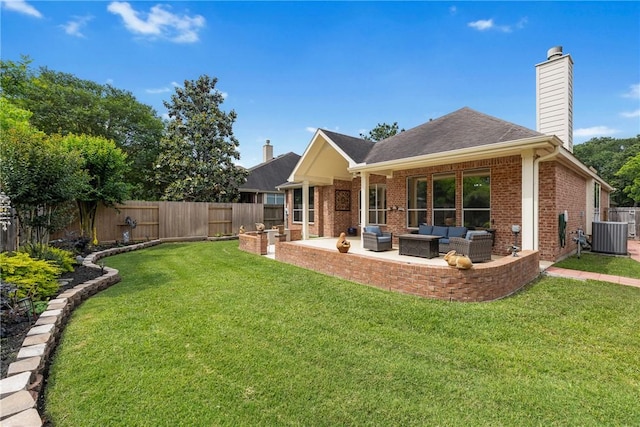 rear view of property featuring a patio, a chimney, an outdoor living space, brick siding, and a yard