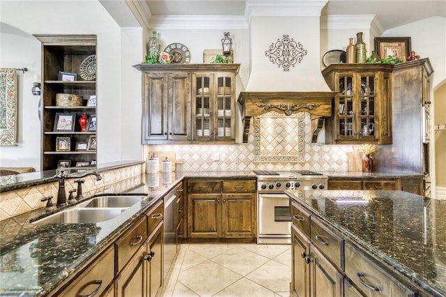 kitchen with crown molding, custom range hood, stainless steel appliances, dark stone counters, and a sink