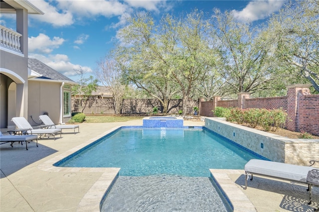 view of swimming pool with a fenced backyard, a pool with connected hot tub, and a patio