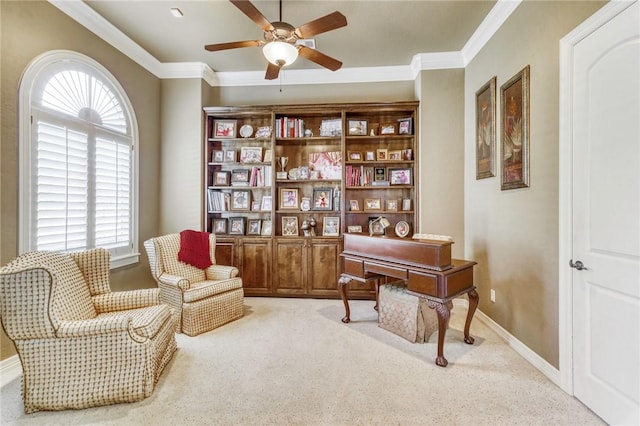 sitting room featuring baseboards, carpet flooring, a ceiling fan, and crown molding