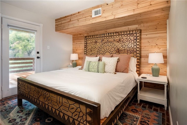 bedroom featuring access to exterior and wooden walls