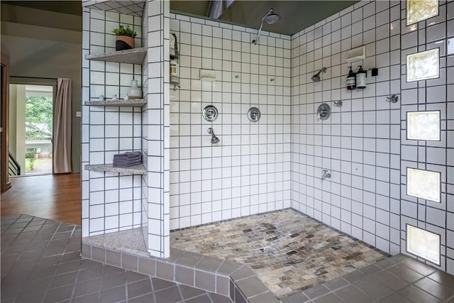 bathroom with tile patterned floors, tile walls, and tiled shower