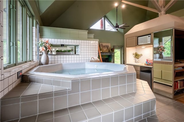 kitchen featuring backsplash, ceiling fan, plenty of natural light, and high vaulted ceiling