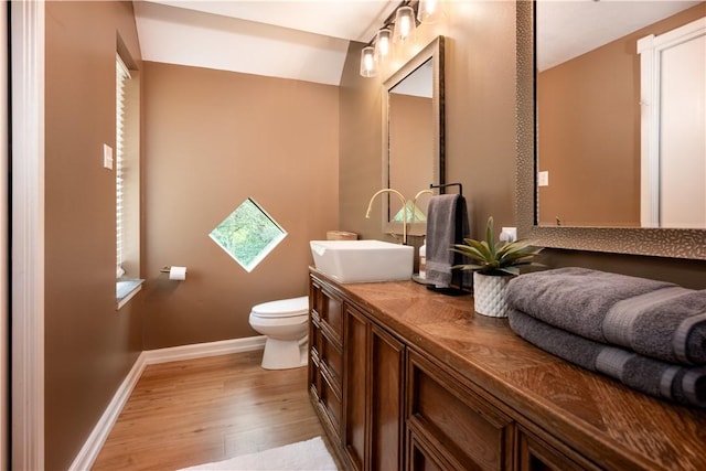 bathroom featuring wood-type flooring, vanity, and toilet