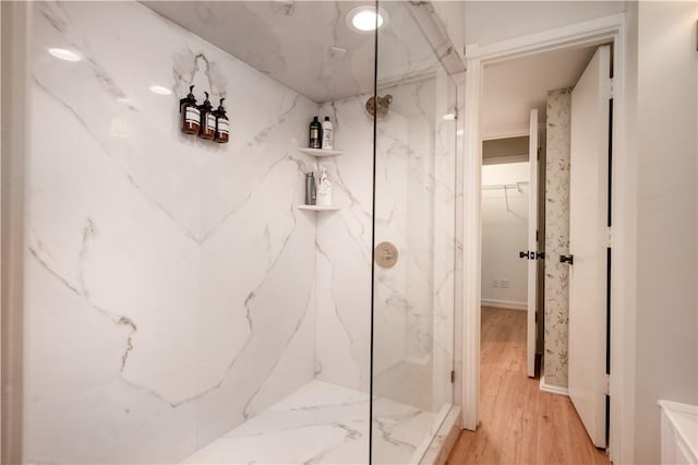 bathroom with hardwood / wood-style flooring and tiled shower