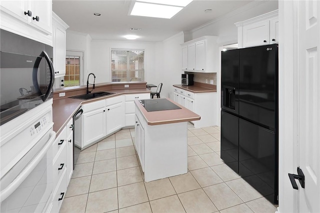 kitchen with a kitchen island, sink, white cabinetry, and black appliances