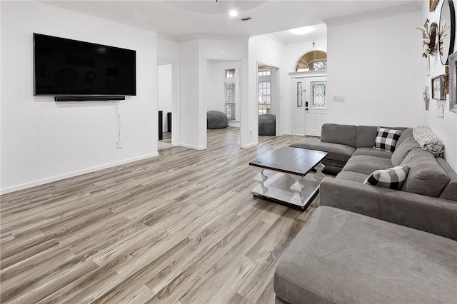 living room with ornamental molding and light hardwood / wood-style floors