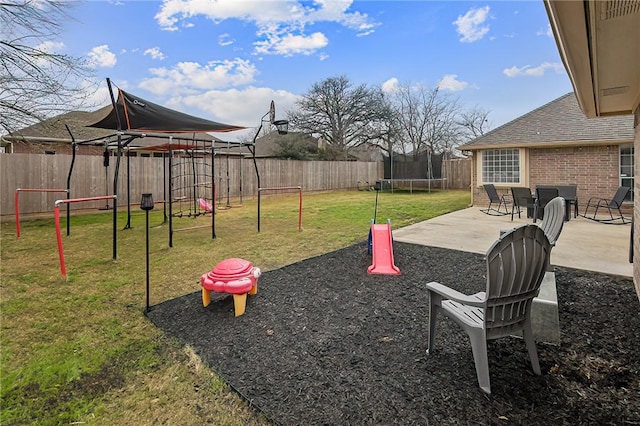 exterior space featuring a trampoline, a lawn, and a patio area