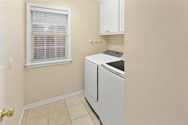 laundry room with independent washer and dryer, light tile patterned floors, and cabinets