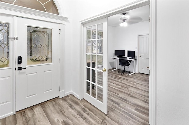 doorway with ceiling fan and light hardwood / wood-style flooring