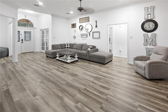 living room with light hardwood / wood-style floors and ornamental molding