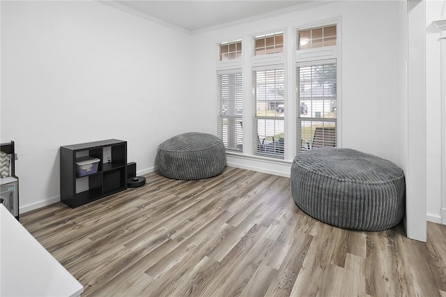 living area featuring hardwood / wood-style flooring and ornamental molding