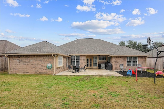 rear view of house with a patio area and a lawn