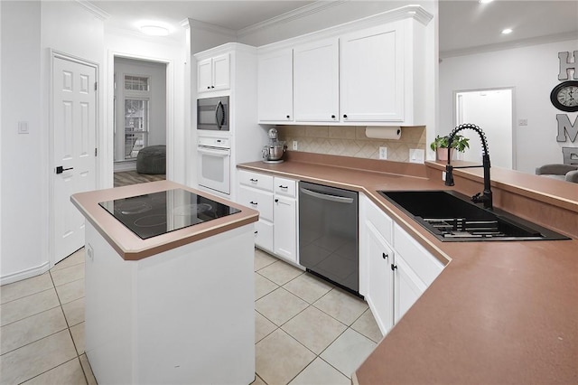 kitchen with appliances with stainless steel finishes, crown molding, light tile patterned floors, sink, and white cabinetry