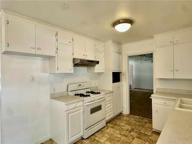 kitchen featuring white range with gas stovetop, white cabinetry, and sink