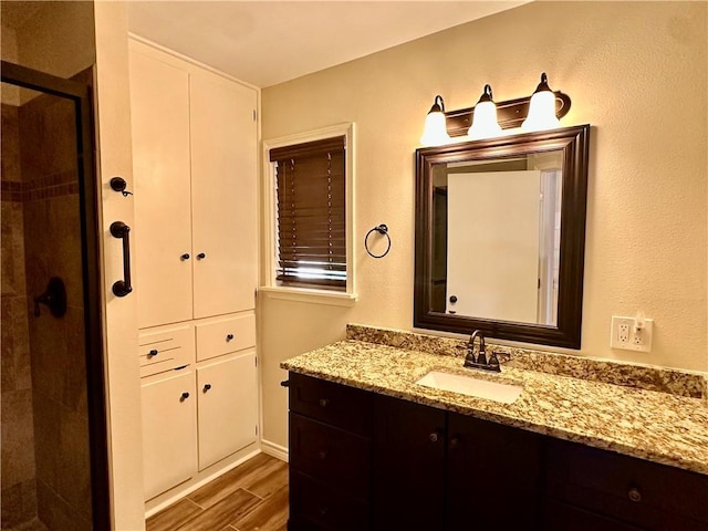 bathroom with vanity, wood-type flooring, and a shower with door