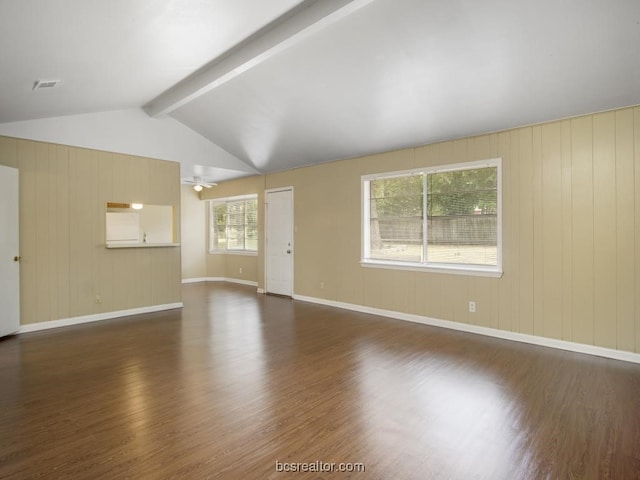 unfurnished living room with dark hardwood / wood-style flooring, lofted ceiling with beams, and plenty of natural light