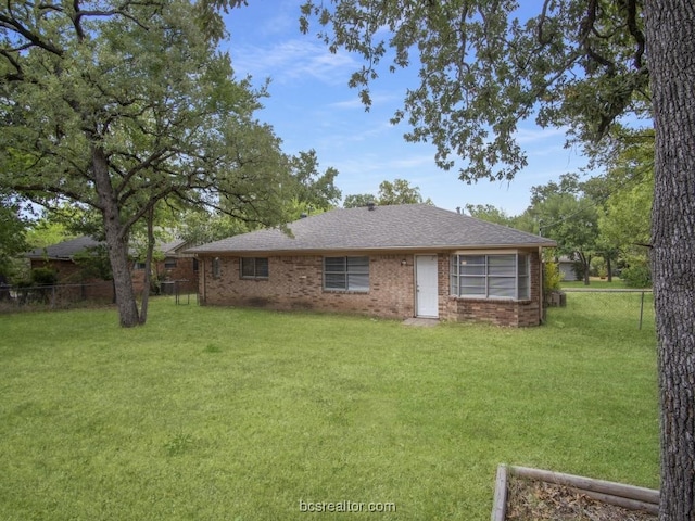 rear view of property featuring a yard