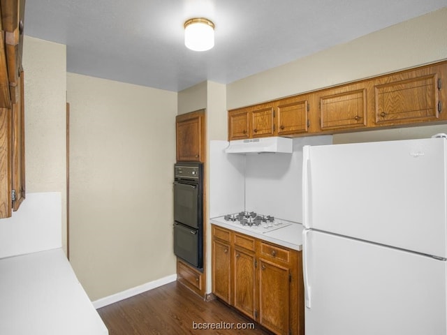 kitchen with dark hardwood / wood-style flooring and white appliances