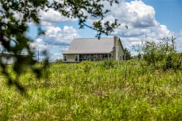 view of home's exterior featuring a chimney and metal roof