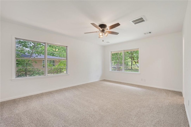 empty room with light colored carpet, visible vents, and ceiling fan