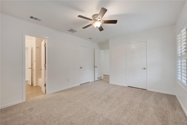 unfurnished bedroom with visible vents, baseboards, and light carpet