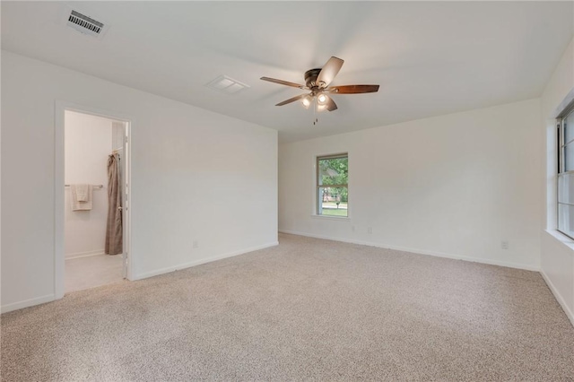 unfurnished room with light colored carpet, visible vents, a ceiling fan, and baseboards