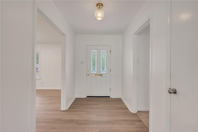 foyer featuring baseboards and light wood-type flooring