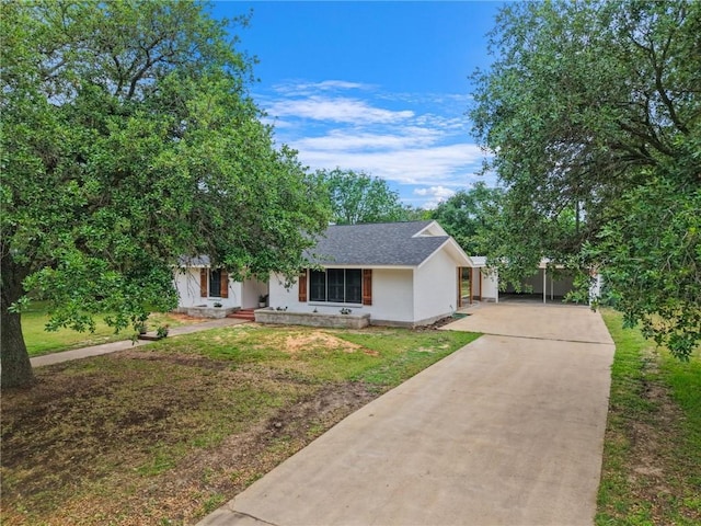 single story home featuring concrete driveway, a front yard, stucco siding, and roof with shingles