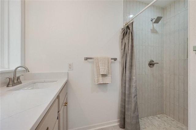full bathroom with tiled shower and vanity