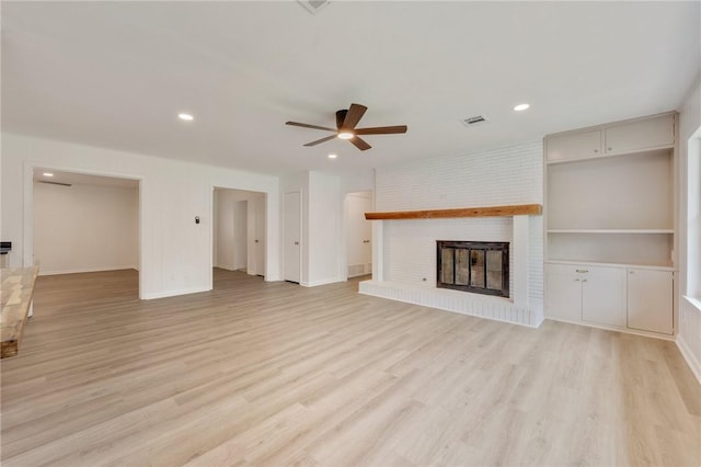 unfurnished living room featuring recessed lighting, ceiling fan, light wood finished floors, a brick fireplace, and visible vents