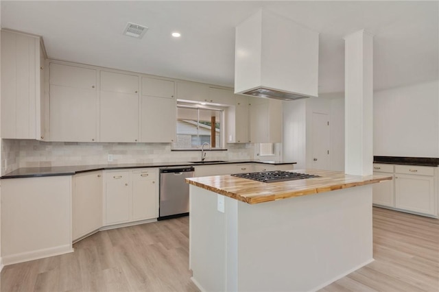 kitchen featuring tasteful backsplash, wood counters, light wood-style floors, dishwasher, and gas stovetop