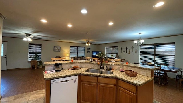 kitchen featuring white dishwasher, sink, hardwood / wood-style flooring, an island with sink, and decorative light fixtures