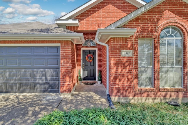 property entrance featuring brick siding, an attached garage, and a shingled roof