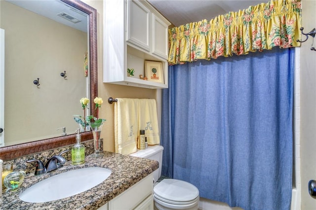 bathroom with vanity, toilet, and visible vents