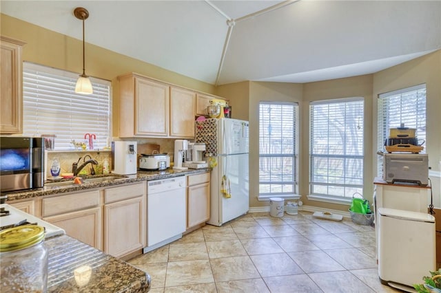 kitchen featuring light brown cabinetry, vaulted ceiling, light tile patterned flooring, hanging light fixtures, and white appliances