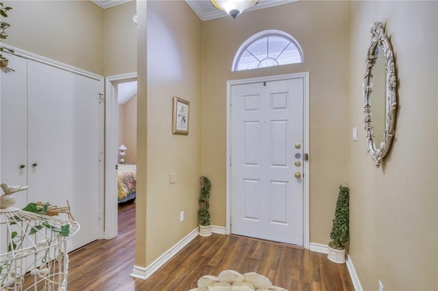 entryway with baseboards, wood finished floors, and crown molding