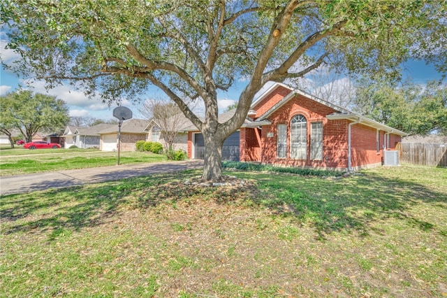 ranch-style home featuring a front lawn, driveway, fence, an attached garage, and brick siding